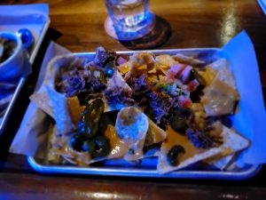 A tray of nachos on a bar in the Beer Temple